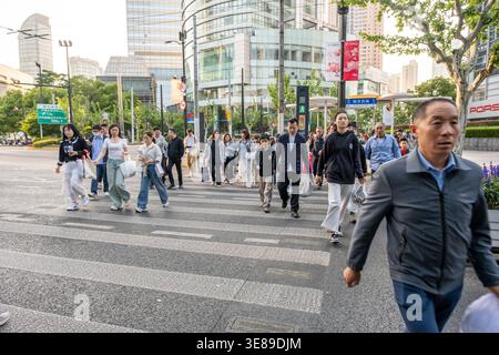 Shanghai, China - 28. April 2025 Menschen gehen auf Zebraüberquerung in Shanghai, China Stockfoto