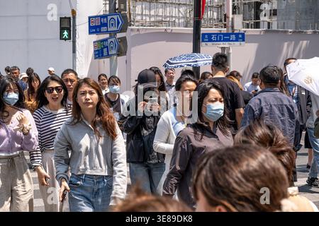 Shanghai, China - 28. April 2025 Menschen gehen auf Zebraüberquerung in Shanghai, China Stockfoto