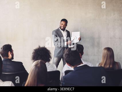 Erfolgreiche Unternehmer, die Diagramme an die Kolleginnen und Kollegen für die Ausbildung Stockfoto