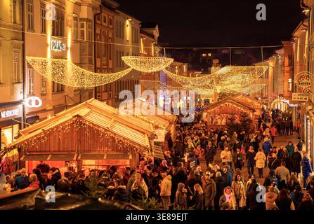Villach, Österreich - 15. November 2024: Weihnachtsmarkt voller Besucher in der Nacht, mit beleuchteten Holzständen und festlicher Dekoration Stockfoto