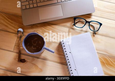 Einrichtung von Fernarbeiten mit Laptop, Kaffee und Notebook Stockfoto