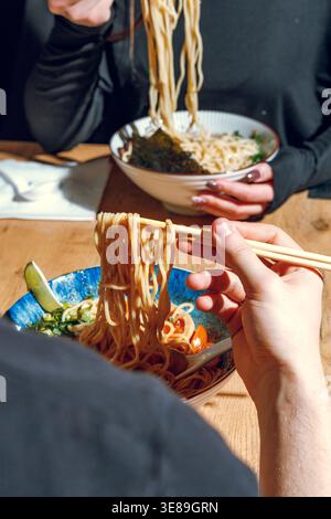 Mann isst Ramen mit Stäbchen. Professionelle Studio-Leuchte Stockfoto