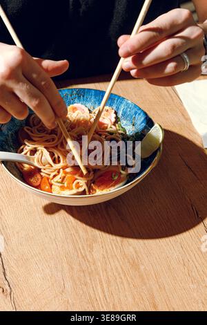 Mann isst Ramen mit Stäbchen. Professionelle Studio-Leuchte Stockfoto