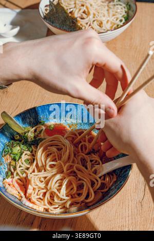 Mann isst Ramen mit Stäbchen. Professionelle Studio-Leuchte Stockfoto