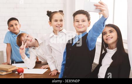 Glückliche Kinder, die Selfie in der Schule machen Stockfoto