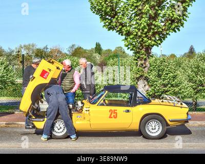 Mechaniker arbeitet an einem Triumph Spitfire während einer Oldtimer-Rallye in Zentralfrankreich. Stockfoto