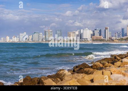 Blick auf die Küste, wo türkisfarbene Wellen auf den Sandstrand und die moderne Skyline von Tel Aviv aus der Altstadt von Jaffa treffen Stockfoto