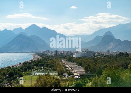 Malerische Türkei mit Bergen und Strand in Antalya Region für Touristen und Kreuzfahrtreisende. Landschaft aus der Vogelperspektive türkisches Resort Konyaalti mit Hotelgebäuden unter hohen Bäumen in der Nähe des Strandes Stockfoto