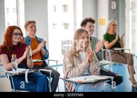 Studenten applaudieren während der Universitätsvorlesung im modernen Klassenzimmer. Stockfoto