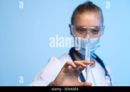 Medizinisches Fachpersonal, das eine Spritze hält, eine Injektion oder einen Impfstoff vorbereitet, um Patienten mit medizinischen Geräten zu schützen Stockfoto