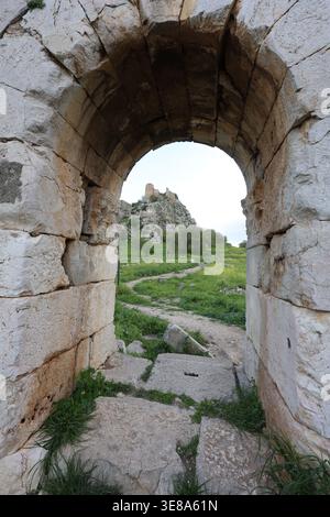Blick auf die mittelalterliche Burg Castabala durch die antike Bogentür der Ruinen der Kirche in Osmaniye, Türkei Stockfoto