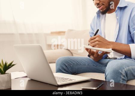 afroamerikaner schreibt kreative Ideen auf Papier Stockfoto