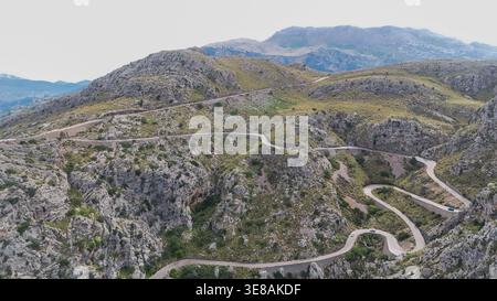 Gewundene Bergstraße, natürliche Landschaft im Hintergrund aus der Vogelperspektive Stockfoto