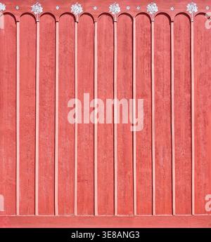 Rote ländliche Holzwand mit dekorativen Weinrebmotiven Stockfoto