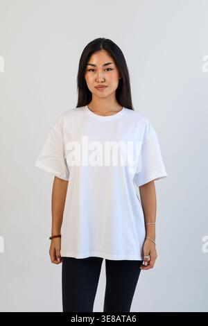 Vorderansicht einer Frau in weißem Hemd. Studio-Porträt einer Frau in lässiger Kleidung mit leerem Hintergrund Stockfoto