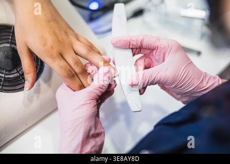 Nageltechniker feilt die Fingernägel des Kunden für die Maniküre Stockfoto