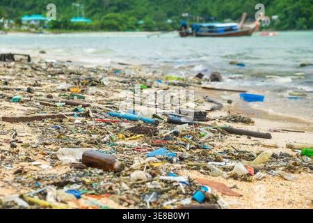 Verschmutzter Strand mit Plastikmüll und Abfall verstreut auf Sandstrand in Thailand. Umweltverschmutzung, die sich auf das Meeresökosystem auswirkt. Nachhaltigkeit Stockfoto