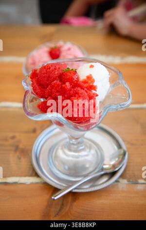 Nahansicht des Desserts mit Kind im Hintergrund, detailliertes Bild der Granita mit verschwommenem Kind im Hintergrund Stockfoto