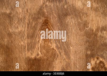 Hintergrund mit natürlicher Holzstruktur mit organischen Kornmustern und einem einzelnen dunklen Knoten, warmbraune Holzoberfläche. Stockfoto