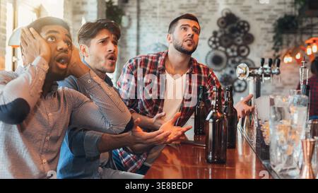 Traurige männliche Freunde, die Football in der Bar gucken Stockfoto