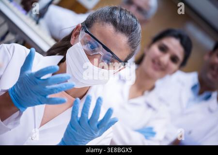 Junge Medizintechniker und Arzte mit Schutzausrüstung in einem klinischen Bluttestlabor Stockfoto