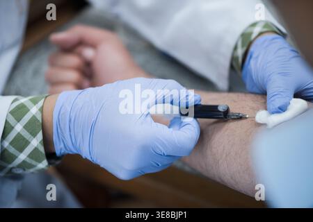 Nahöstliche Ärzte und Techniker, die Bluttest und Venenpunktion im klinischen Labor durchführen Stockfoto