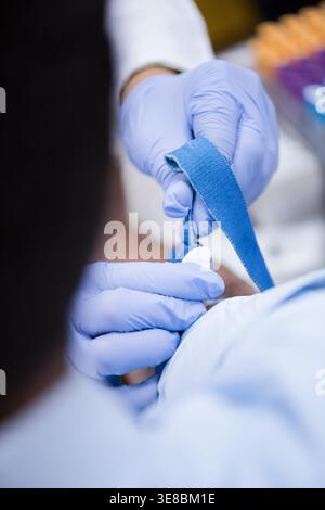 Junge Medizintechniker, die eine Blutentnahme mit Handschuhen in einem klinischen Labor vorbereiten Stockfoto