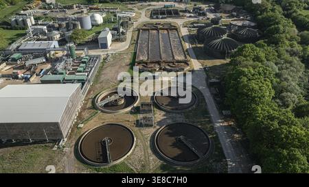 Aus der Vogelperspektive ist eine weitläufige Abwasseraufbereitungsanlage mit großen, markanten Tanks und verschiedenen Aufbereitungseinheiten sichtbar. Dieser Standort ist für die folgenden Zwecke ausgelegt Stockfoto