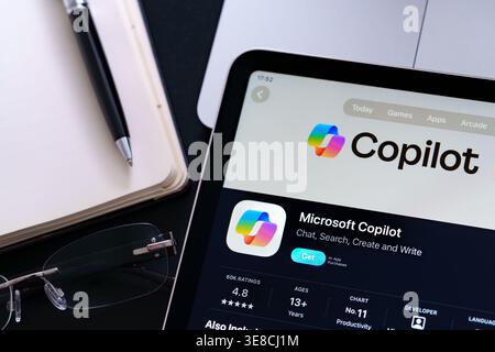 Die Microsoft Copilot-Liste auf dem iPad hebt das aktualisierte Design von Apple Liquid Glass und den iOS 26-Look in der Büroschreibtischszene hervor. Stafford, Vereinigtes Königreich, 1. April Stockfoto