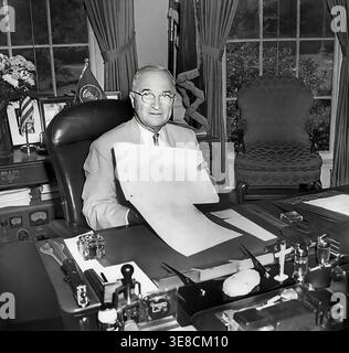 US-Präsident Harry S. Truman zeigt die Änderungen des National Security Act von 1949, die er gerade an seinem Schreibtisch im Oval-Büro des Weißen Hauses in Washington, D.C., USA, unterzeichnet hatte. National Parks Service, Harry S. Truman Library, 10. August 1949 Stockfoto