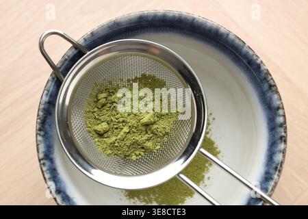 Matcha-Pulver in einer Schüssel am Holztisch, Draufsicht Stockfoto
