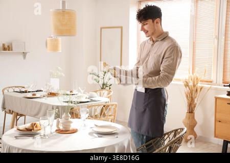 Junge Kellner, die einen Tisch im Restaurant gedeckt haben Stockfoto