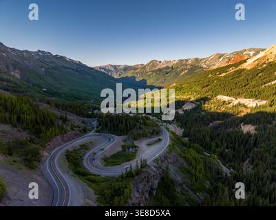 Windeseile des Million Dollar Highway (US-550) am Red Mountain Pass, Colorado. Dramatische Aussicht auf Berggipfel und Alpenwald aus der Vogelperspektive. Stockfoto