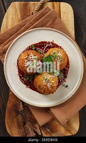 Knusprige Arancini-Vorspeise mit Parmesan und Mikrogrün, Teller, Tomatensauce, hausgemacht, keine Leute Stockfoto