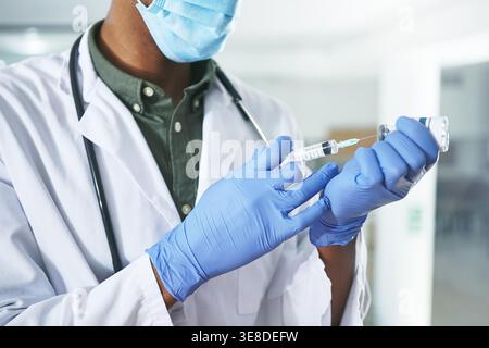 Arzt, Impfstoff und Gesichtsmaske mit Händen im Krankenhaus für klinische Studie, Apotheke Formel und Medizin. Krankheitsprotokoll, Gesundheitssicherheit und Medikamente Stockfoto