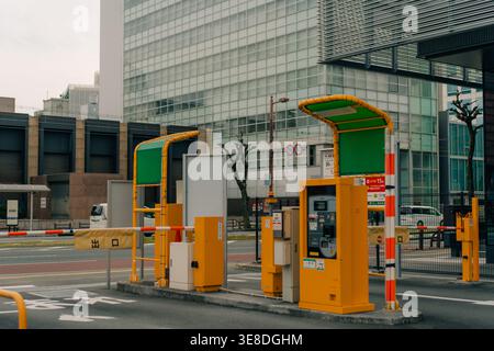 Automatisches Parkzahlungssystem mit Schranktoren in Japan, das moderne städtische Infrastruktur für den Fahrzeugzugang und die Zahlungssteuerung zeigt. Stockfoto
