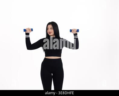 Frau, die mit Kurzhanteln auf weißem Hintergrund arbeitet Stockfoto