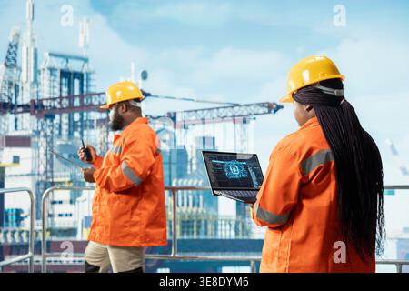Techniker auf Offshore-Plattform, die künstliche Intelligenz auf einem Laptop nutzen, um Bohrvorgänge zu optimieren. afroamerikanische Kollegen überwachen die Aktivität von Binnenschiffen mit KI Stockfoto
