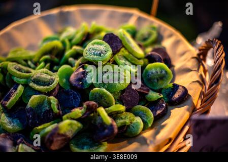 Nahaufnahme getrockneter Kiwischeiben in einem Korb auf einem Markt im Freien in Civita di Bagnoregio, Italien. Farbenfrohe, natürliche Snackpräsentation für Speisen Stockfoto