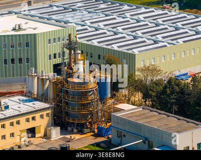 Luftansicht auf Industriegebäude mit Solarpaneelen auf Dächern und komplexe Maschinentürme in Prato, Toskana, Italien. Stockfoto