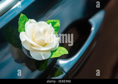 Auto mit Dekorationen aus Blumen für Braut und Bräutigam während der Hochzeit fahren Stockfoto