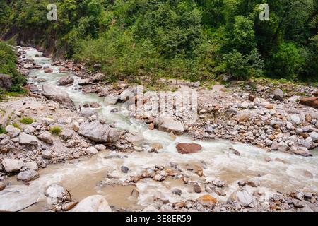 Ein ruhiger Fluss fließt durch eine felsige Landschaft in der Nähe des majestätischen Madmaheshwar Tempels in Uttarakhand, Indien. Die ruhige Atmosphäre ist umgeben von l Stockfoto
