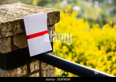 Weißes Buch mit rotem Band auf Steinmauer Stockfoto