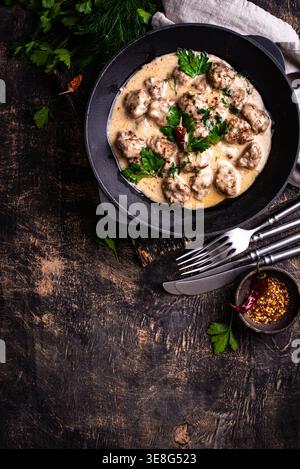 Fleischbällchen in Sauerrahmsauce in einer Pfanne Stockfoto