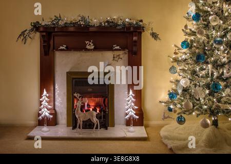 Gemütliches weihnachtliches Wohnzimmer mit dekoriertem Baum, beleuchtetem Kamin und festlichen Dekorationen schaffen eine warme saisonale Inneneinrichtung Stockfoto