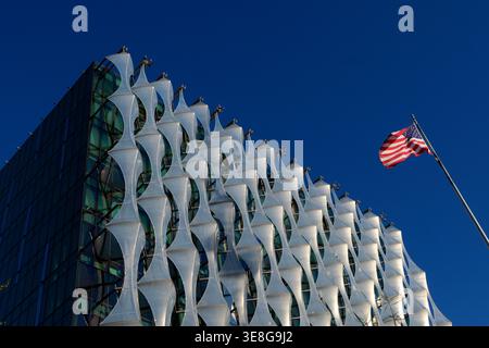 Außenansicht der Gebäudefassade der US-Botschaft mit der im Wind winkenden amerikanischen Flagge an einem sonnigen, klaren Himmel in London, Großbritannien. Stockfoto