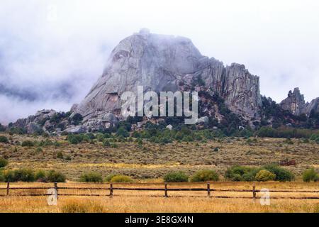 Der massive Granitmonolith von Castle Rock ragt über einer nebeligen Wiese im Castle Rocks State Park, Idaho. Stockfoto