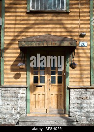 Doppeltür aus Holz mit Baldachin und hängenden Blumenkörben an einer traditionellen Hausfassade in Kalamaja, Tallinn, Estland Stockfoto