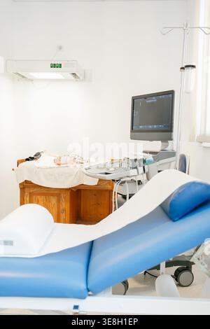 Neugeborenes liegend auf dem ärztlichen Untersuchungstisch für Ultraschallverfahren vorbereitet. Konzept der Neugeborenen-, Gesundheits-, Pädiatrie- und Frühversorgung Stockfoto