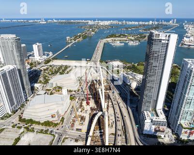 Aus der Vogelperspektive blickt man auf eine lebhafte Stadtlandschaft, in der glitzernde Wolkenkratzer auf das türkisfarbene Wasser der Biscayne Bay treffen, unter dem klaren blauen Himmel, Miami, Florida, USA Stockfoto